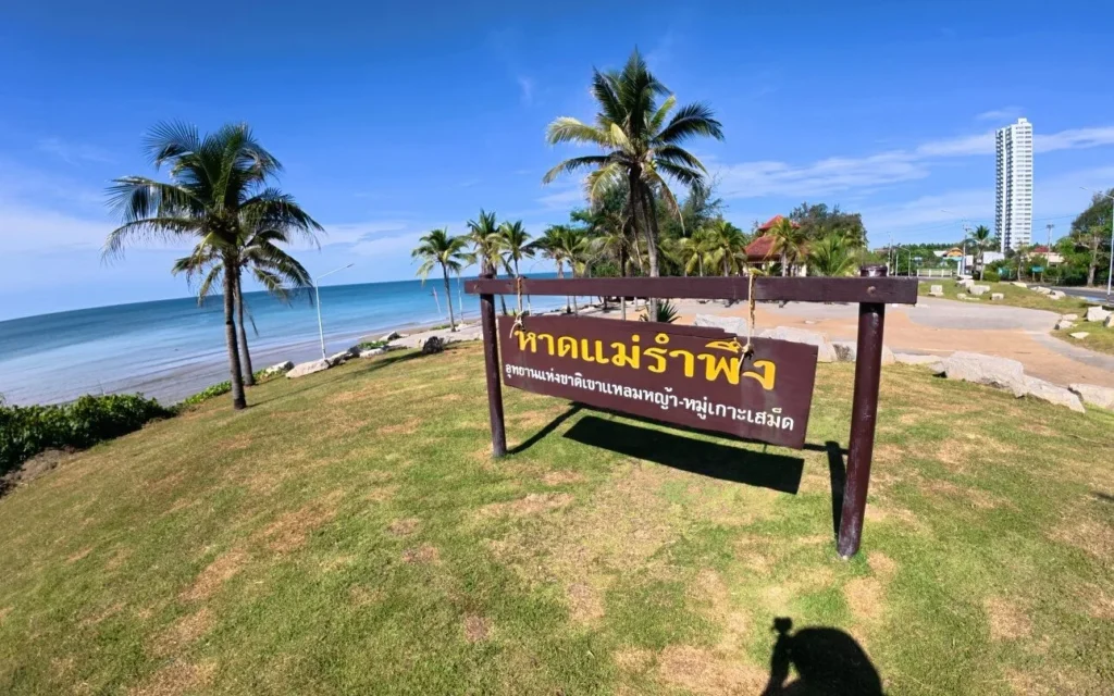 หาดแม่รำพึง จังหวัดระยอง ชายหาดทรายยาวริมทะเลอ่าวไทย บรรยากาศเงียบสงบ รายล้อมด้วยต้นสนและท้องฟ้าสีคราม