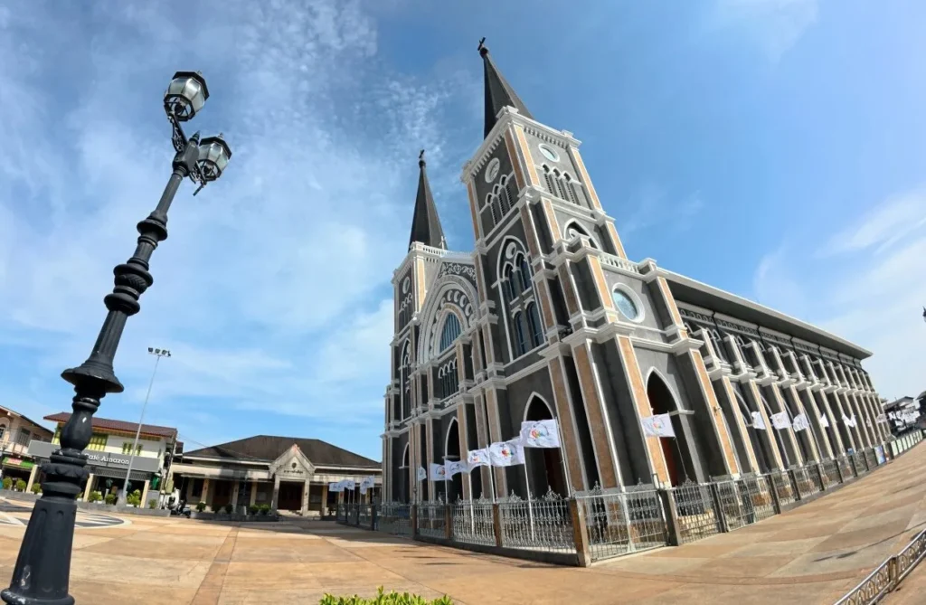อาสนวิหารพระนางมารีอาปฏิสนธินิรมล จันทบุรี อาคารสไตล์โกธิกยอดแหลมคู่ ภายนอกสีเทาส้ม และภายในโบสถ์โอ่อ่าประดับกระจกสี