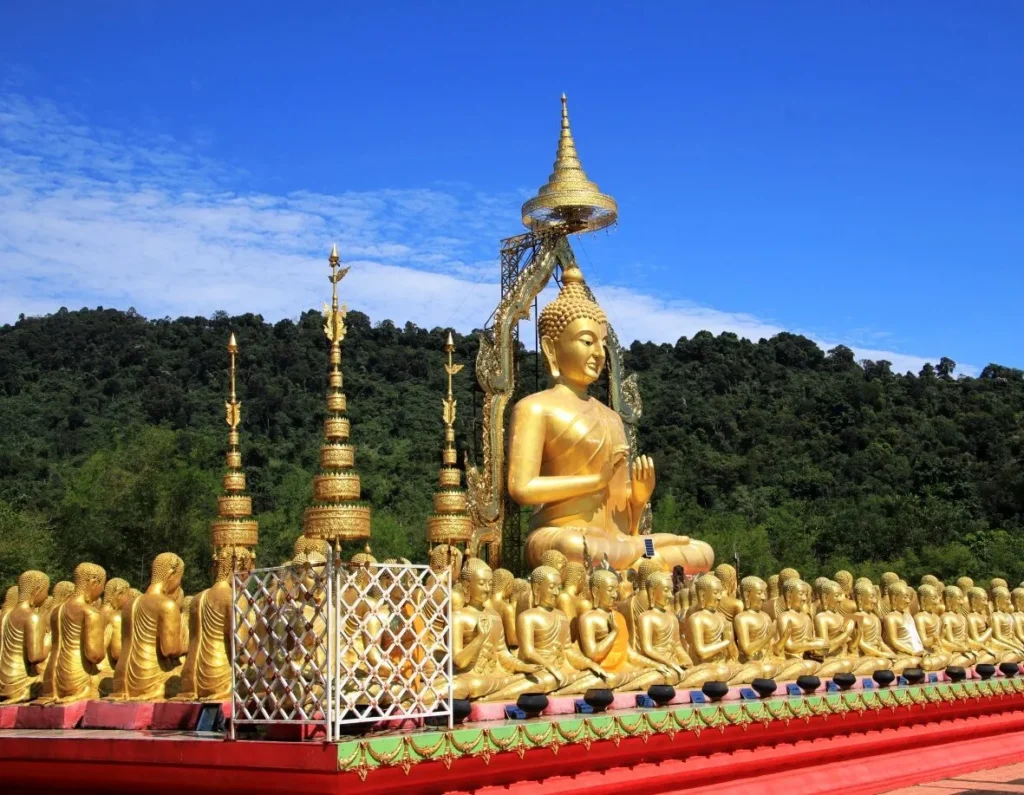 พระพุทธรูปสีทององค์ใหญ่ รายล้อมด้วยพระสาวกจำนวนมาก ภายในพุทธอุทยานมาฆบูชาอนุสรณ์ นครนายก