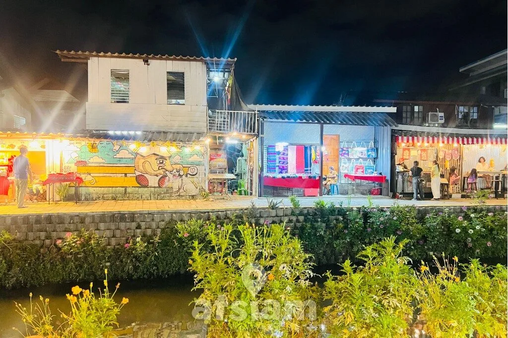 คลองแม่ข่า เชียงใหม่ ในยามค่ำ คือพื้นที่เล็ก ๆ ที่เปลี่ยนบรรยากาศเมืองให้ดูนุ่มลง แสงไฟ เสียงคน และผิวน้ำที่สะท้อนทุกอย่างเข้าหากันอย่างลงตัว

“บางคืนไม่ต้องมีแผน แค่มีแสงไฟ น้ำ และทางเดิน ก็พอให้ความสุขเกิดขึ้นได้”