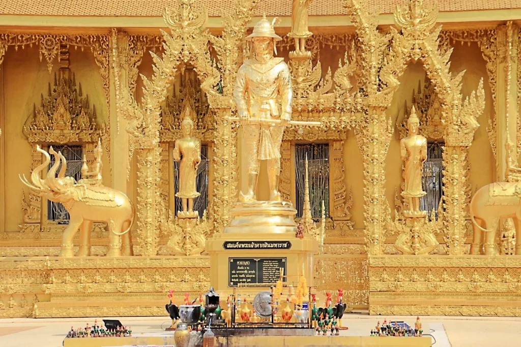 แท่นบูชาสีทองพร้อมรูปปั้นสมเด็จพระเจ้าตากสินและช้าง ตกแต่งด้วยลวดลายไทยละเอียด และเครื่องสักการะด้านหน้า