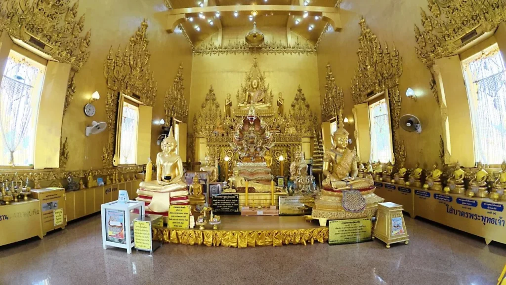 ภายในวิหารสีทอง ประดิษฐานพระพุทธรูปและเครื่องบูชาหลากหลาย ท่ามกลางการตกแต่งสีทองทั้งห้อง