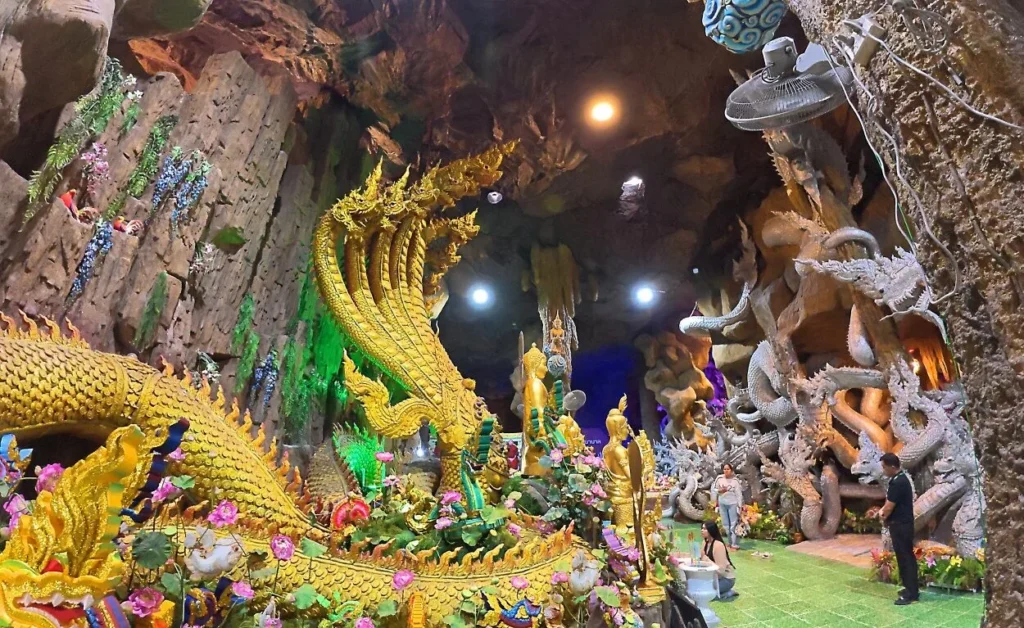 ภายในถ้ำพญานาควัดมณีวงศ์ จังหวัดนครนายก ประดิษฐานพระพุทธรูปท่ามกลางประติมากรรมพญานาคสีทอง